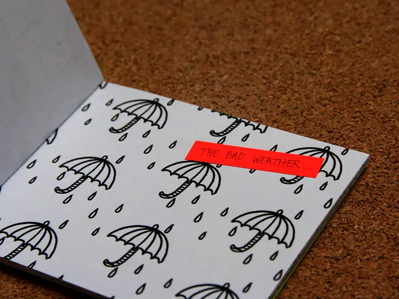 Cette page du livret Welcome to LH est tramée de parapluie et de gouttes d'eau. Le texte "the bad weather" est inscrit sur un papier orange fluo.